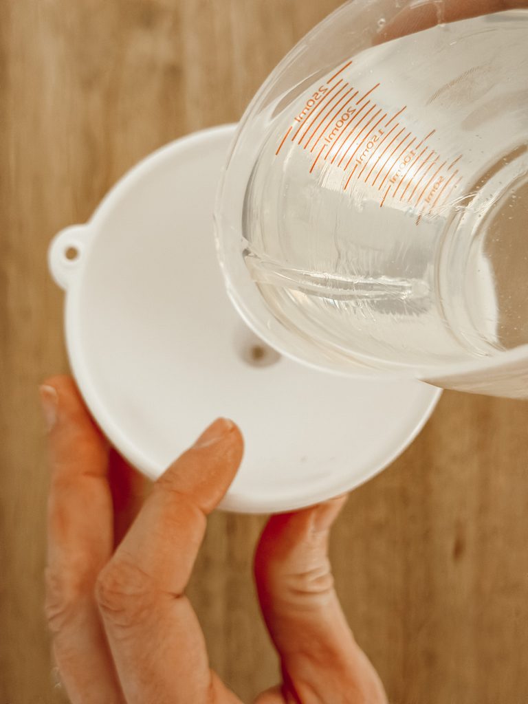 Pour the faux water into a vase using a funnel for easy clean up.
