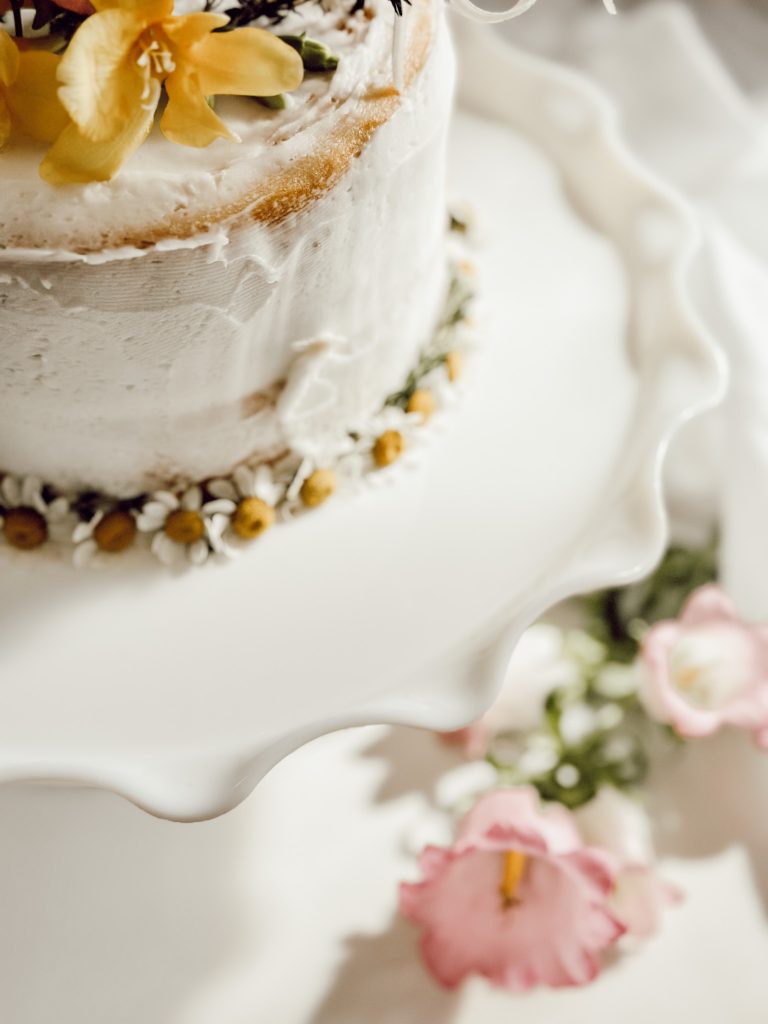 Spring flowers on a rustic, round cake for spring celebrations.