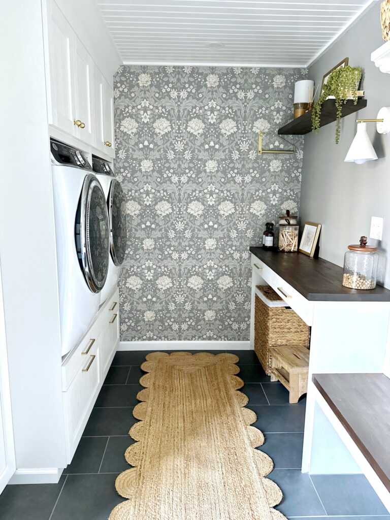 Galley style laundry room with a feature all in the back with floral wallpaper. Adding some much needed pattern to this space. 