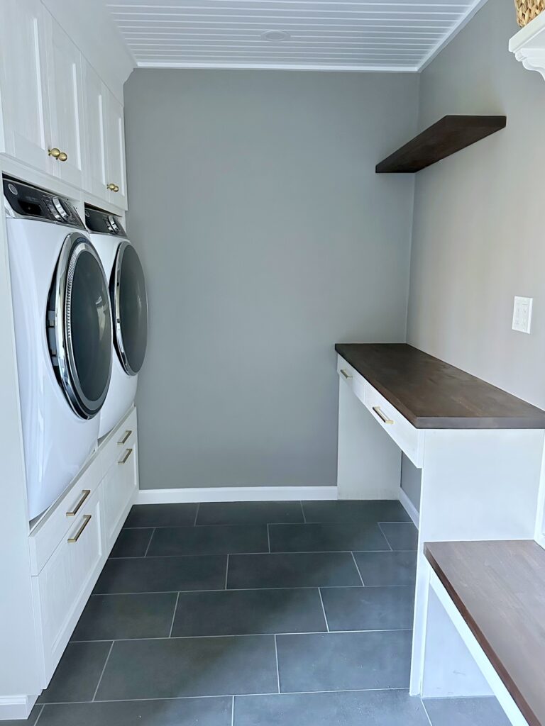 Laundry room with a blank back wall prior to adding wallpaper. 