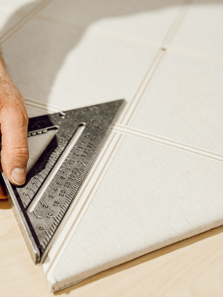 Use a triangle to measure the ribbon on the pin board to create equally sized sections.