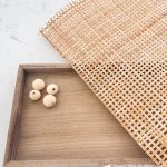 Supplies to make a wood and cane tray: wood tray, cane, wood beads.