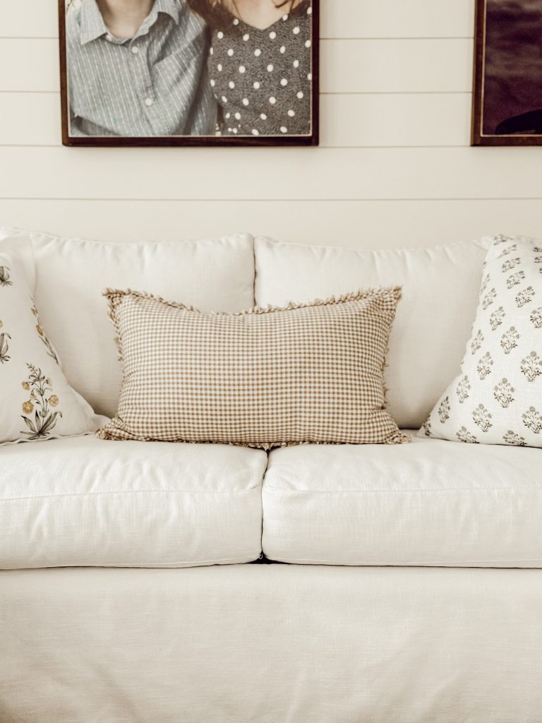 Gingham throw pillow with other patterned throw pillows on the sofa.