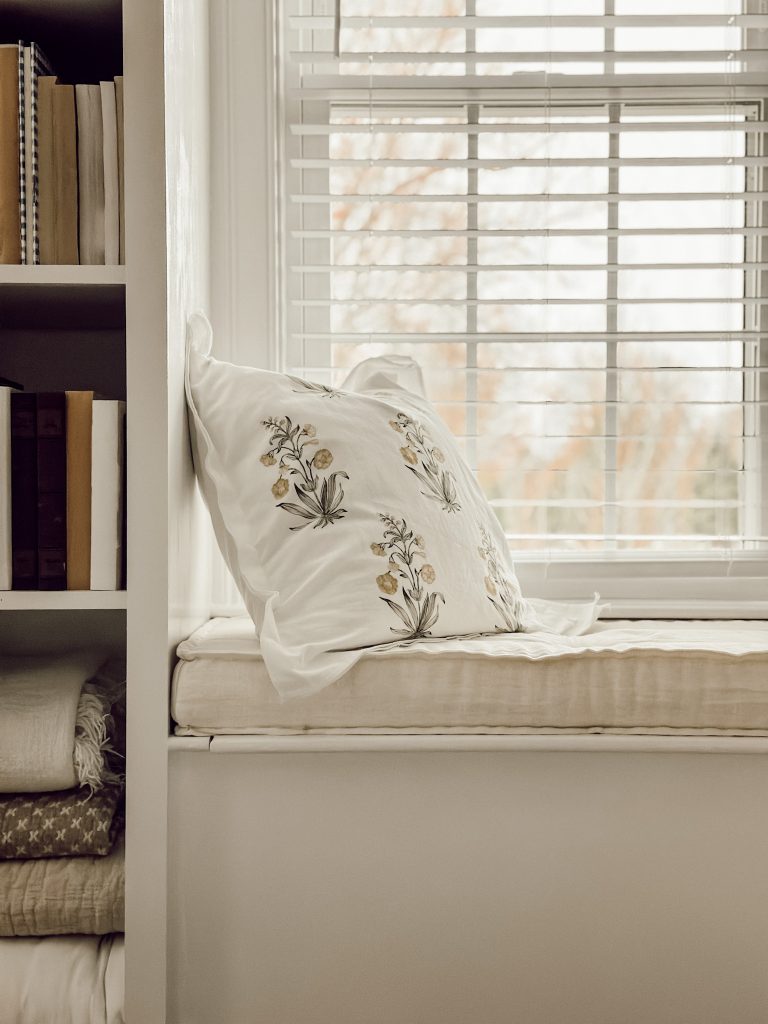 Patterned decorative pillow on a window seat in the family room.
