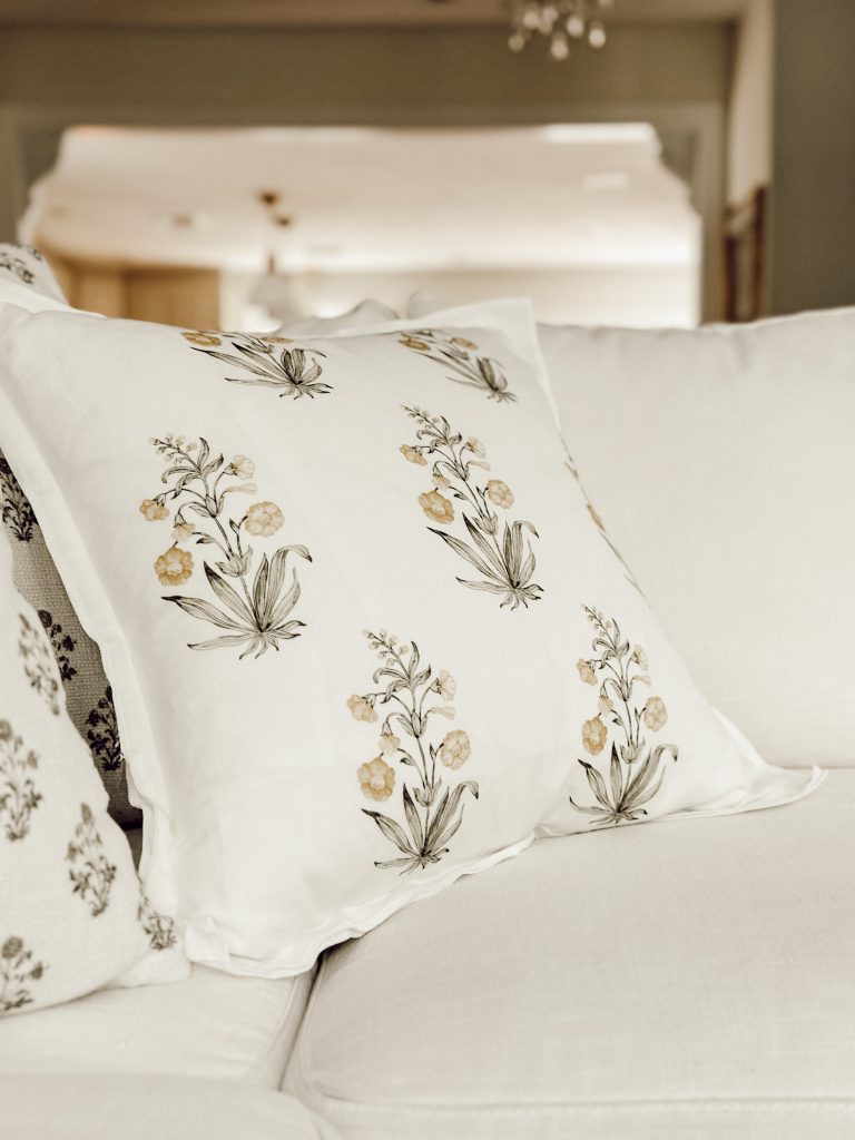 Botanical block print pillow on a white sofa in farmhouse home decor.