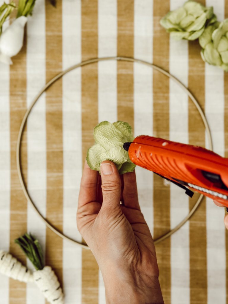 Use a low temperature glue gun to secure the vegetables to the wreath form.