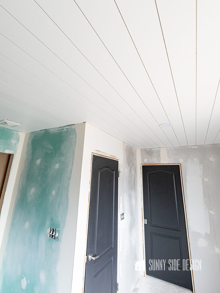 Shiplap bathroom ceiling painted white, walls mudded and ready for primer and paint.