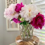 A beautiful bouquet of mixed pink peonies in a glass vase.
